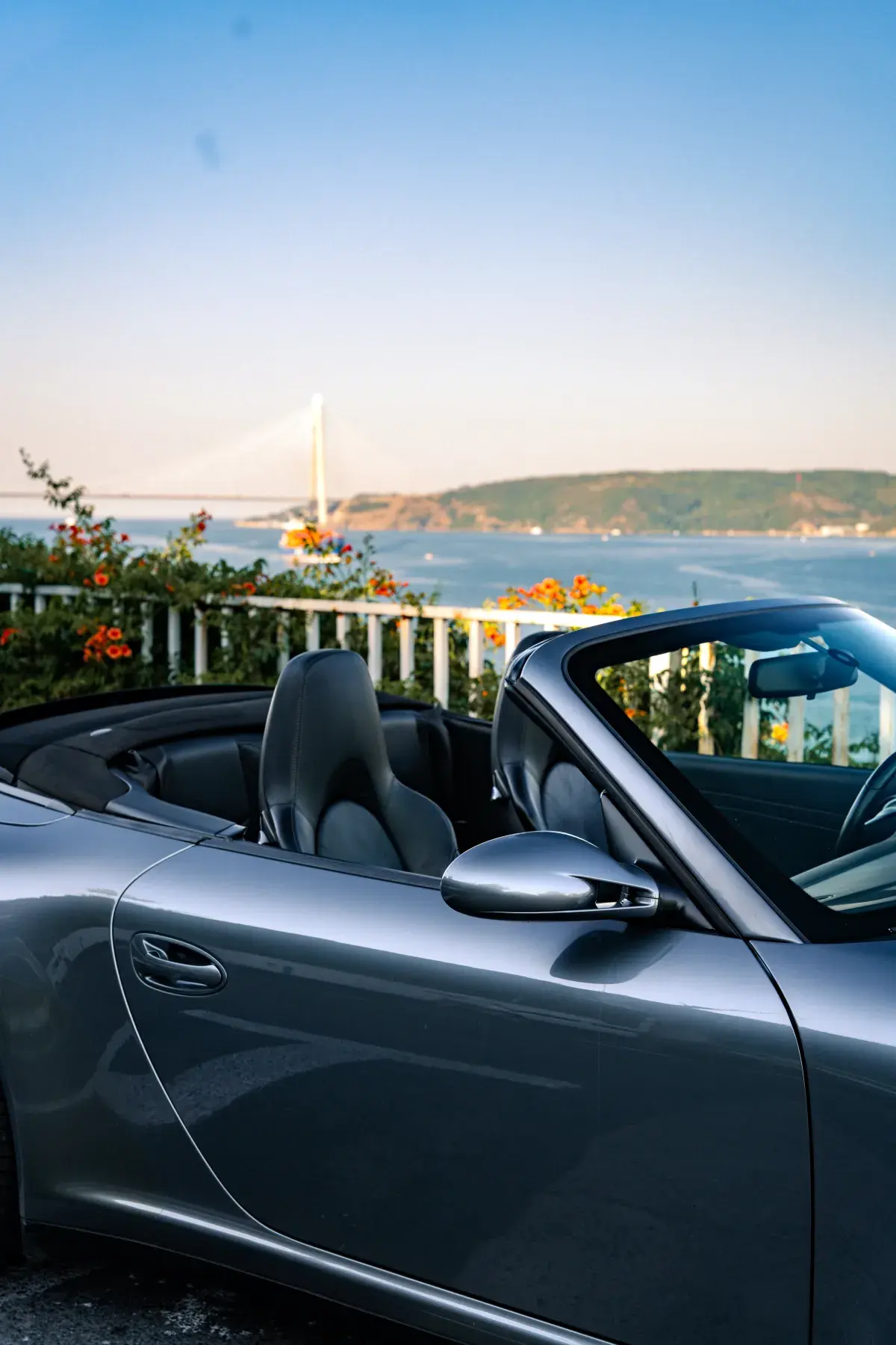 Gümüş Porsche cabrio köprü manzarasında